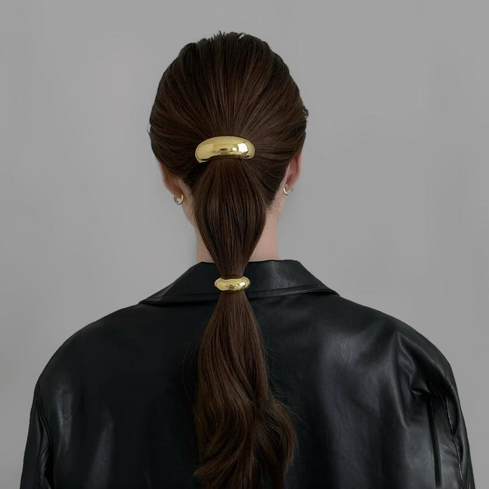 Model wearing two gold  Gleaming Curve Hair Cuffs , great for everyday styling and gifting.