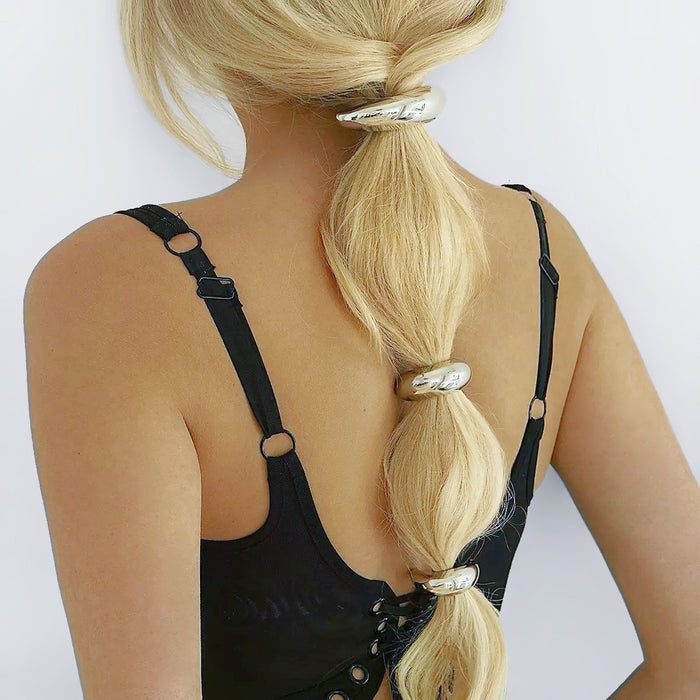 Blonde hair styled with three silver Gleaming Curve Hair Cuffs, ideal for quick updos and ponytails.