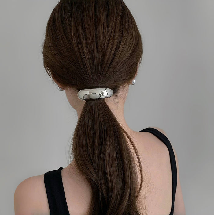 Model wearing a silver Gleaming Curve Hair Cuff, great for everyday styling and gifting.