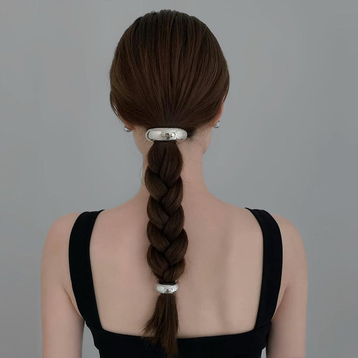 Model wearing two silver Gleaming Curve Hair Cuffs, ideal for quick updos and ponytails.