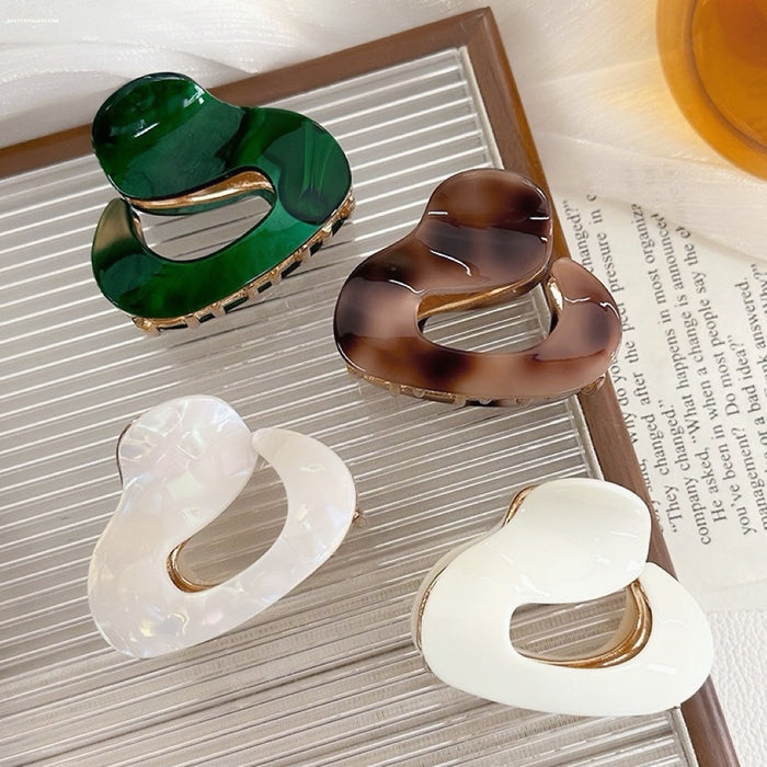 Front view of Four glossy acrylic cloud hair claws in dark green, brown,pure white, and white luster.