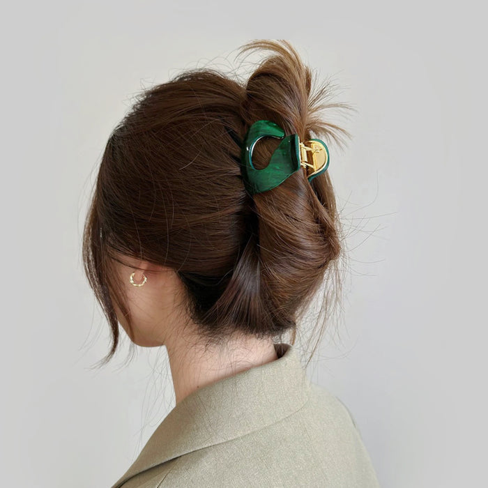 Model wearing a Glossy Cloud Hair Claw  in dark green, easy for workdays and special occasions.