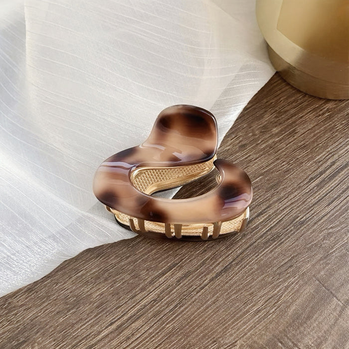 Model wearing a brown acrylic hair claw clip, great for date nights and events.