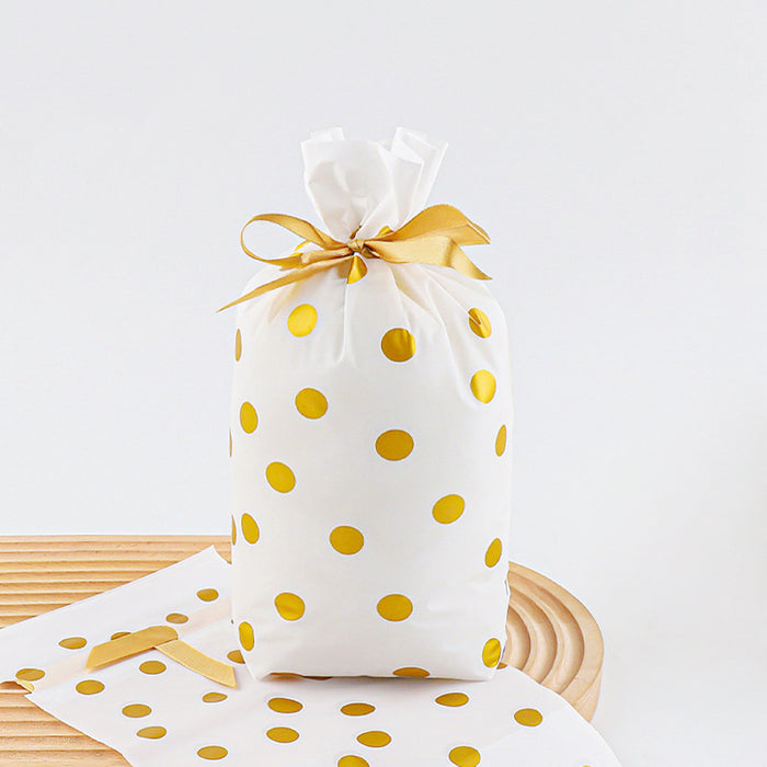 Front view of White PE gift bag with gold polka dots and a gold satin ribbon drawstring closure.