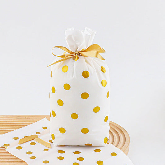 Front view of White PE gift bag with gold polka dots and a gold satin ribbon drawstring closure.