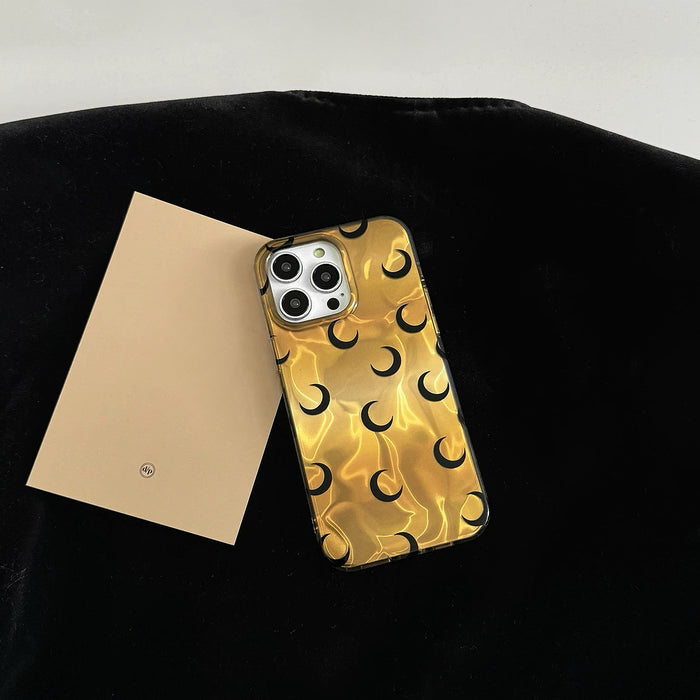 Shiny gold silicone background with black crescent moon motifs. Elegant celestial-themed phone cover.