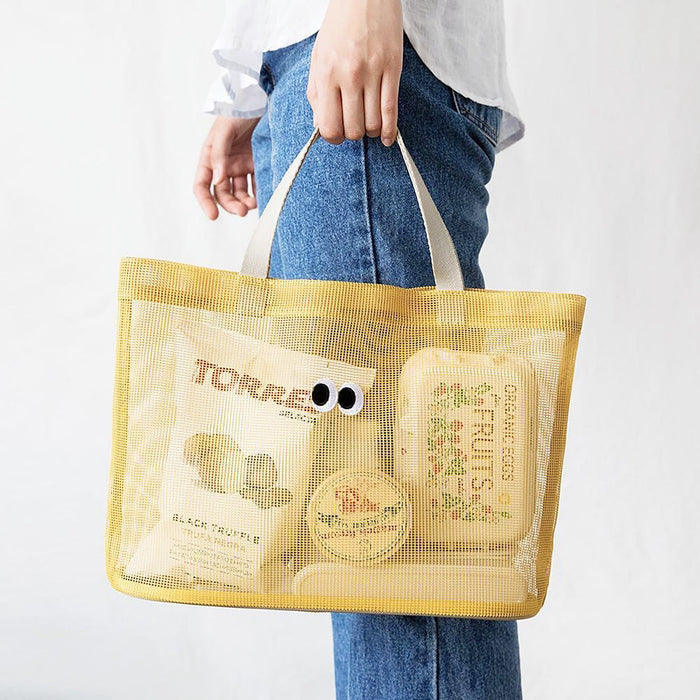Model carrying a yellow Googly Eyes Mesh Tote Bag handheld , great for daily carry and travel.