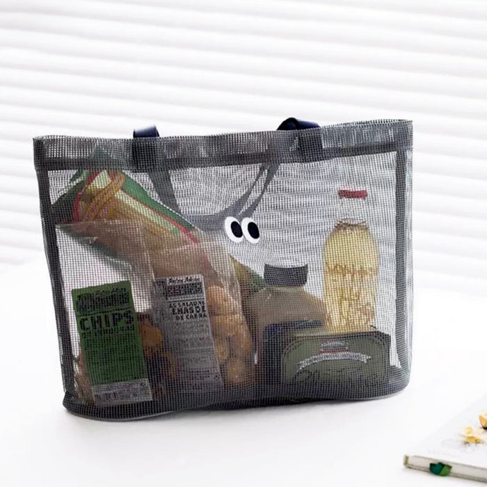 Close-up of Black polyester mesh tote bag with googly eyes, filled with snacks and items in gray.