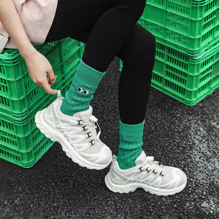 Close-up of model wearing Googly Eyes Socks in green, easy to pack for travel and errands.