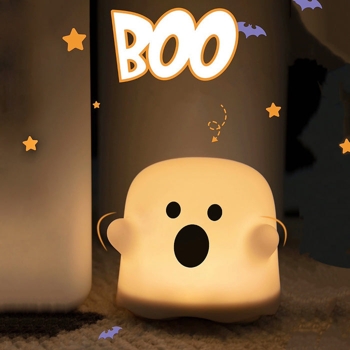 Front view of Glowing white plastic ghost lamp with black eyes and mouth.