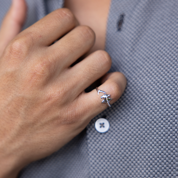 Close up of a man's hand holding his collar and wearing a Hammerhead Shark Ring in Sterling Silver