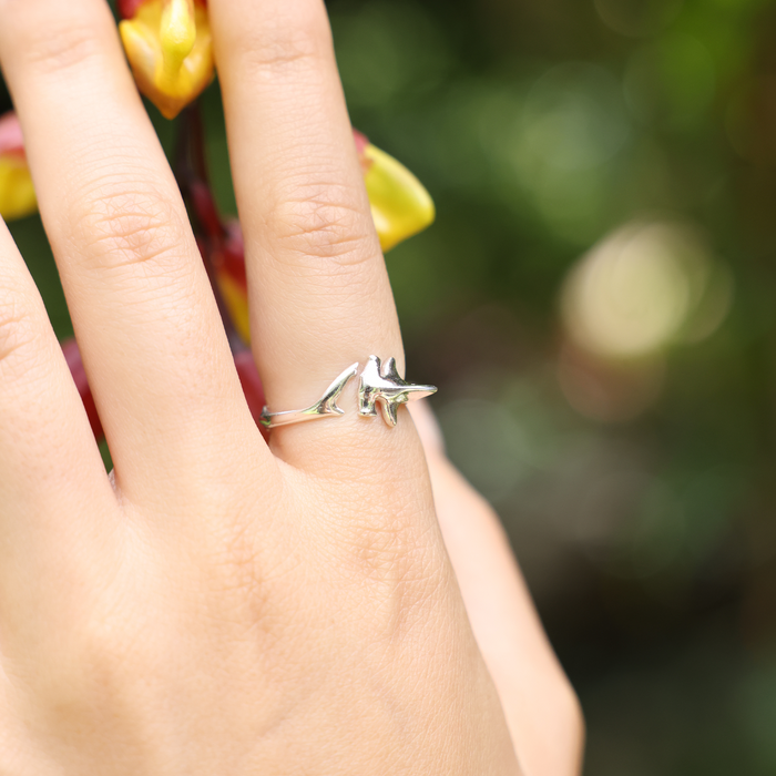 Close up of a person's hand wearing a Hammerhead Shark Ring in Sterling Silver against a green background