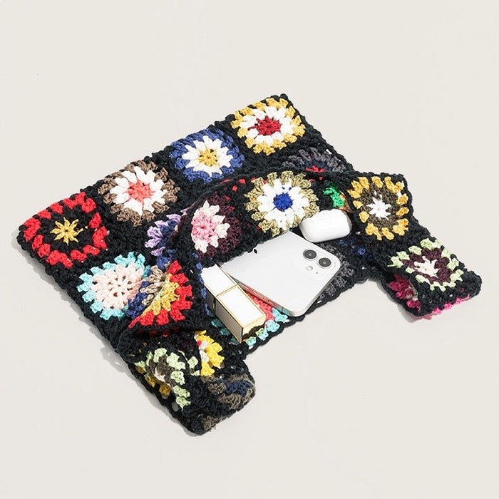 Flat lay of Handmade Crochet Flower Grid Bag in black, great for everyday carry and travel.