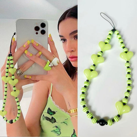Model grabing a phone with lime green heart beat phone charm.