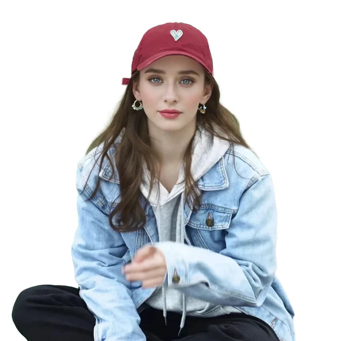 Model wearing a red cotton baseball cap with white heart embroidery.