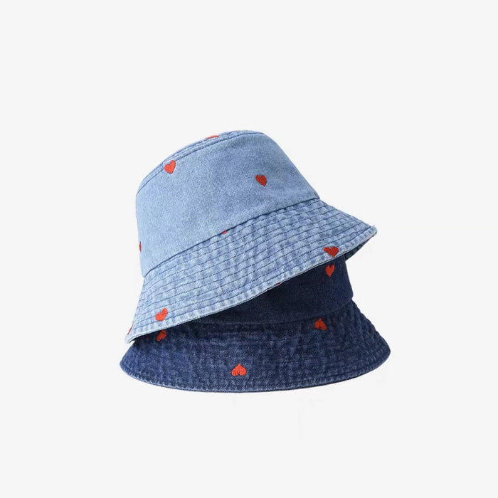 Light and dark wash denim bucket hats with red heart prints, offering a rugged yet romantic summer aesthetic.