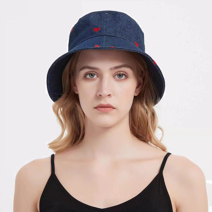 Denim bucket hat with a red heart print on a woman, a durable and trendy accessory for beach sun protection.