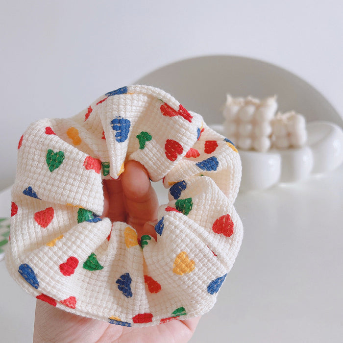 Angled view of Heart Printed Scrunchie, ideal for quick updos and ponytails.