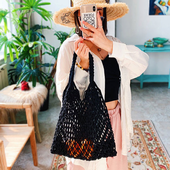Model carrying a black cotton tote bag on the shoulder, great for daily carry and travel.