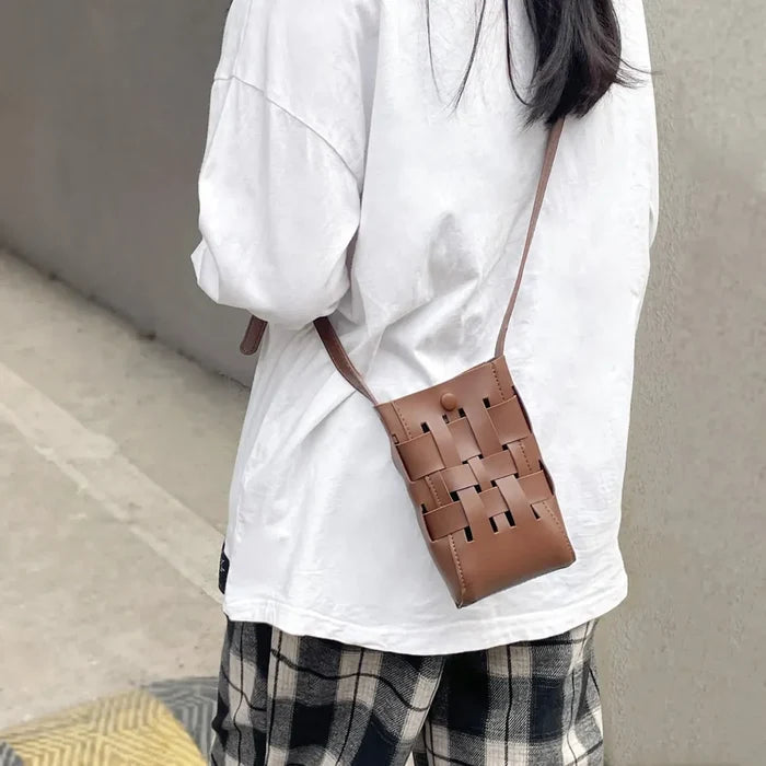 Model carrying a brown Hollow Design Woven Leather Crossbody Bag as crossbody, great for daily carry and travel.
