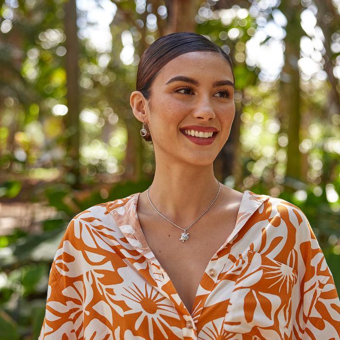 Woman in a garden wearing Honu Pendant / Charm in Sterling Silver with Wave earrings