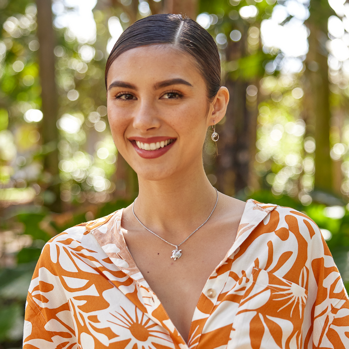 Woman in a garden wearing Honu Pendant / Charm in Sterling Silver and Wave earrings