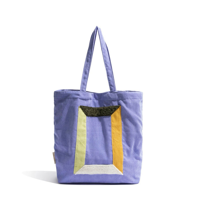 Front view of Lavender corduroy tote bag with colorful geometric panel design and two grab straps in lilac
