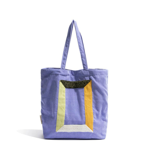 Front view of Lavender corduroy tote bag with colorful geometric panel design and two grab straps in lilac