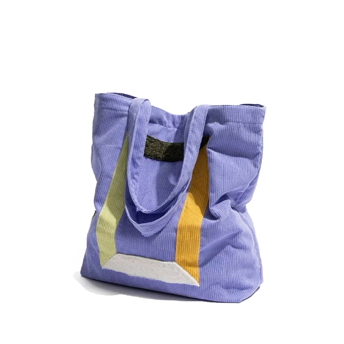 Close-up of Hued panel corduroy tote bag in light purple with yellow, green, and white color block accents in lilac.