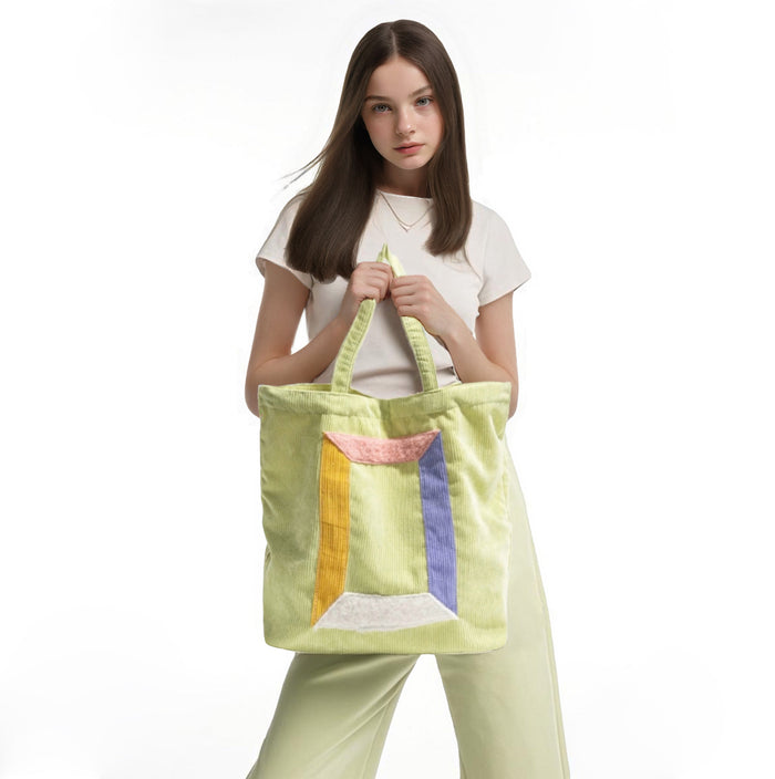 Model carrying a green tote bag handheld, easy for commuting and weekends.