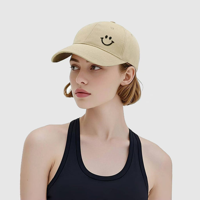 Model wearing Joyful Grin Cap in beige, displays iconic smile graphic for a subtle yet playful everyday accessory.