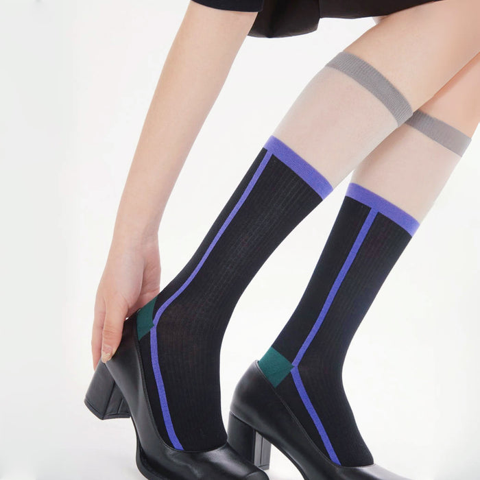 Model wearing a pair of Juicy Patchwork Knee-high Socks in black, easy to pack for travel and errands.
