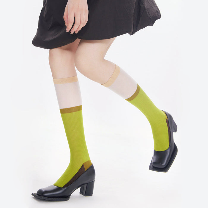 Model wearing a pair of olive green cotton knee-high socks, great for casual wear and light workouts.