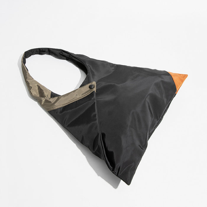 Flat lay of the geometric triangle tote bag highlighting the foldable design and orange corner accent.