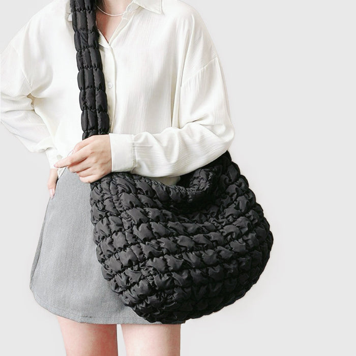 Model styling the black puffy quilted crossbody bag for a casual outfit.