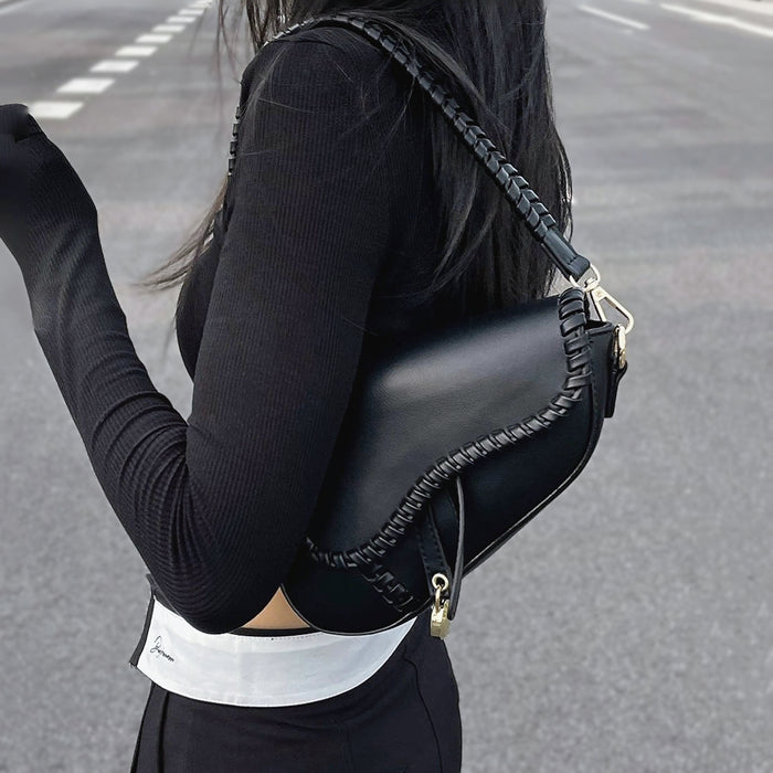 Model carrying a black shoulder bag, ideal for city walks and gifting.