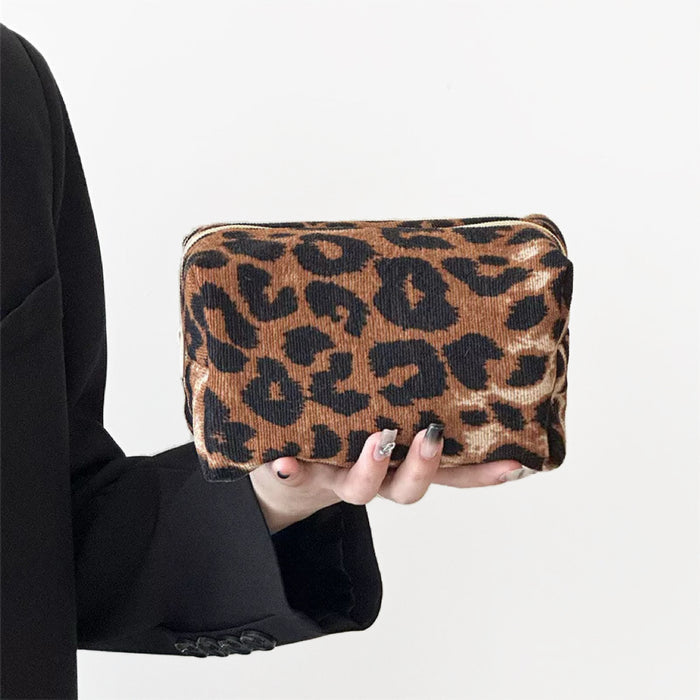 Model holding a brown leopard print makeup bag in hand, ideal for daily makeup essentials.