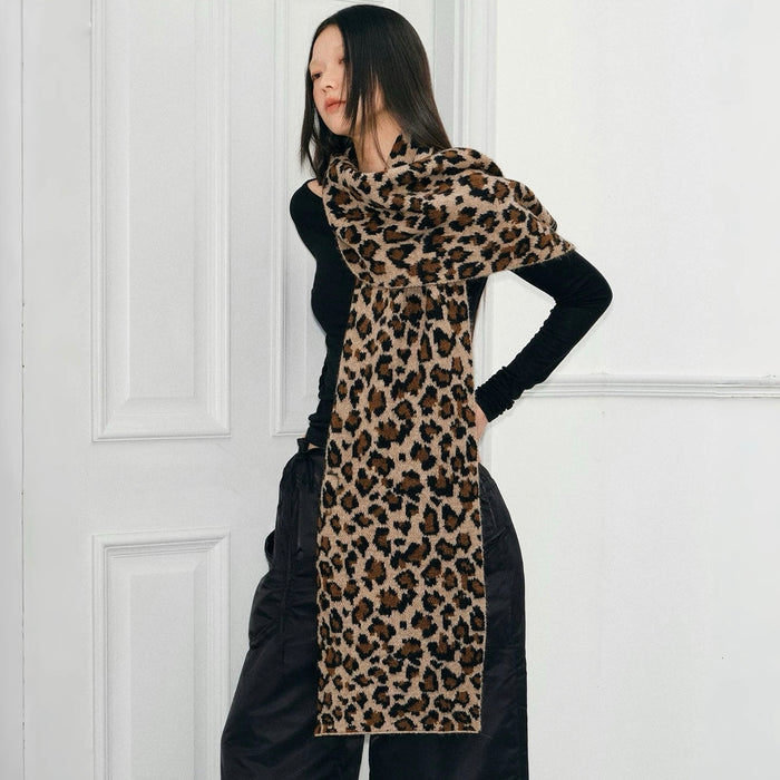 Model wearing long, wool blend leopard print knit scarf in brown and black, great for office layering and commuting.