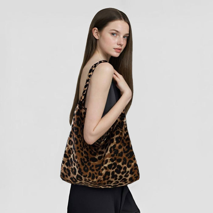 Model holding a leopard print polyester leisure tote bag, 15.7W x 13.8H, with a black dress.