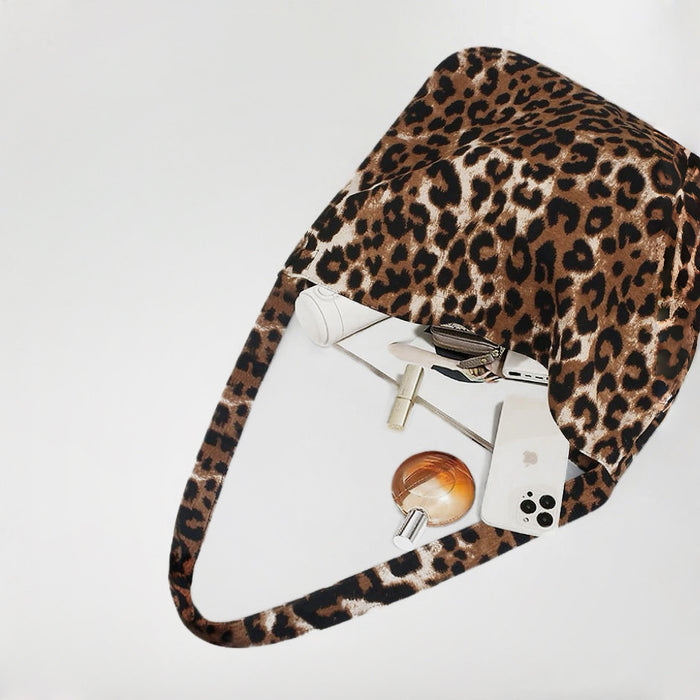 Polyester leopard print leisure tote bag with inner pockets, holding a phone, perfume, and cosmetics.