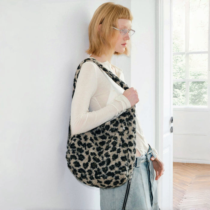 Model carrying a leopard print polyester tote bag on the shoulder , easy for commuting.