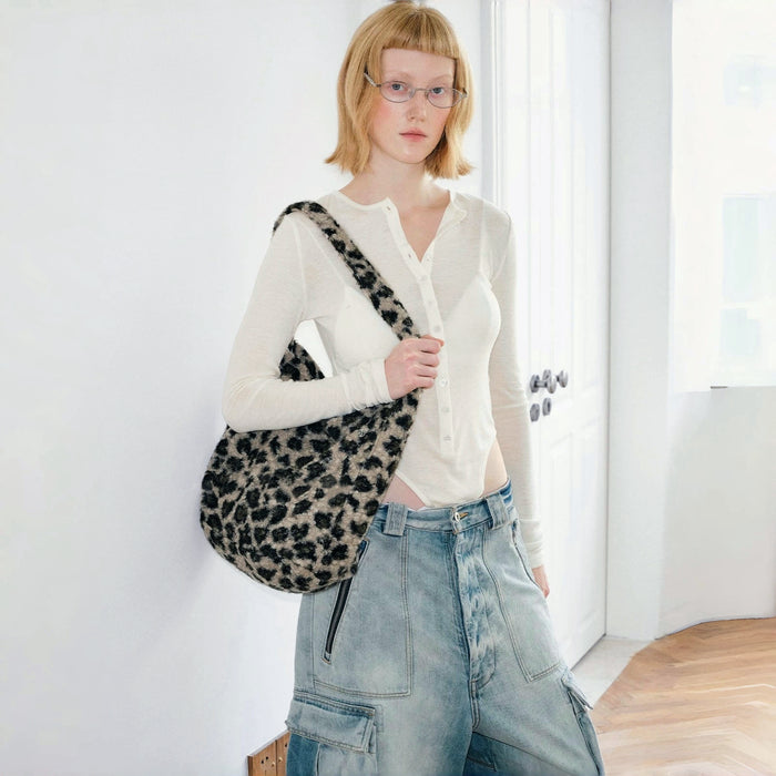 Model carrying a leopard print polyester tote bag on the shoulder , ideal for city walks.