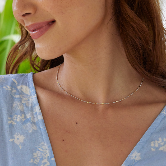 Close up of a woman in a garden wearing Link Chain in Sterling Silver and Yellow Gold