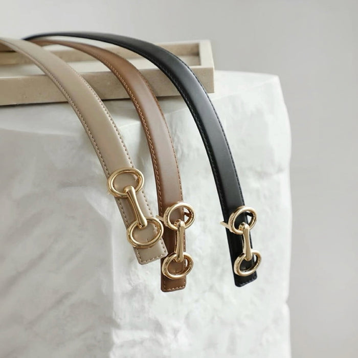 Close-up of three Linked Loop Belts in brown, black, and khaki, showing the gold-tone buckle detail .