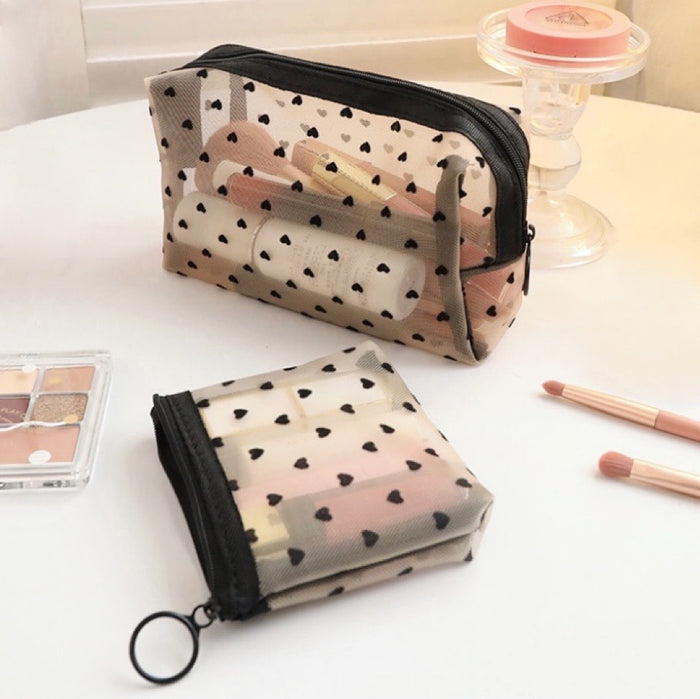 Two heart print organza bags on a vanity table, one mini and one rectangle.