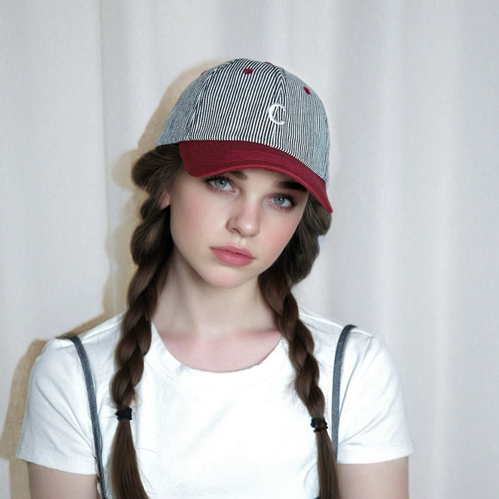 Model wearing red Mash Up Stripe C Cap, showcasing eclectic striped patterns for a bold, athletic summer look.