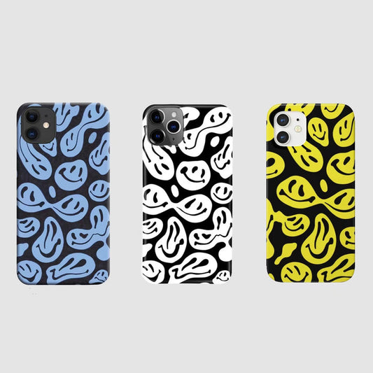 Three silicone cases with melting smiley patterns in blue, white, and yellow on black. Pop-art aesthetic.