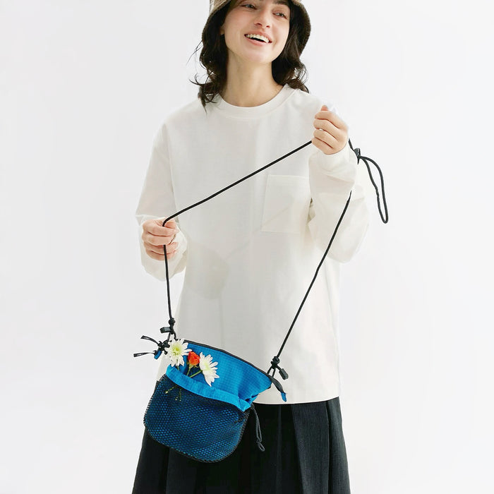 Model holding the blue Mesh Vogue Crossbody Bag, easy for commuting and weekends.