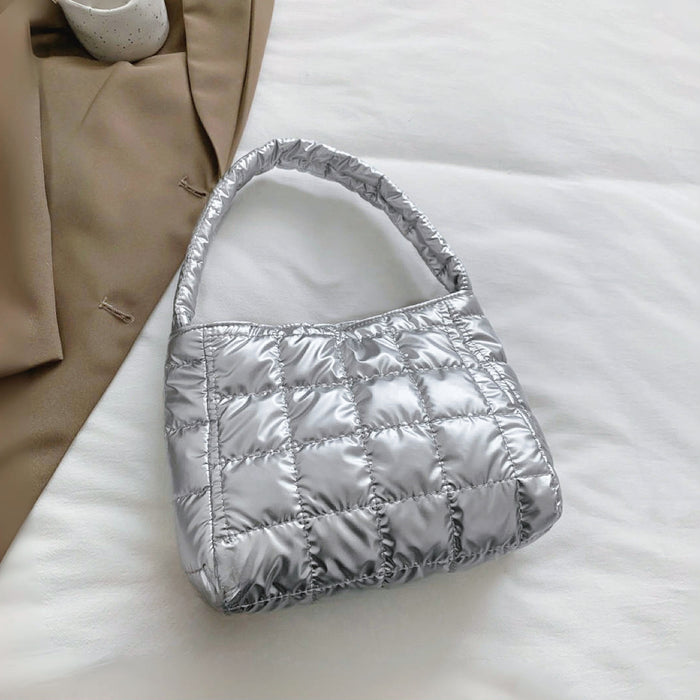 Close-up of Silver metallic polyester quilted shoulder bag with a magnetic closure, ideal for errands and gifting.