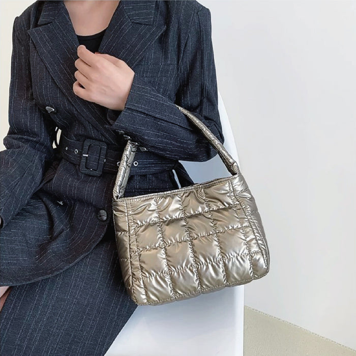 Model carrying a gold polyester bag handheld, great for daily carry and travel.